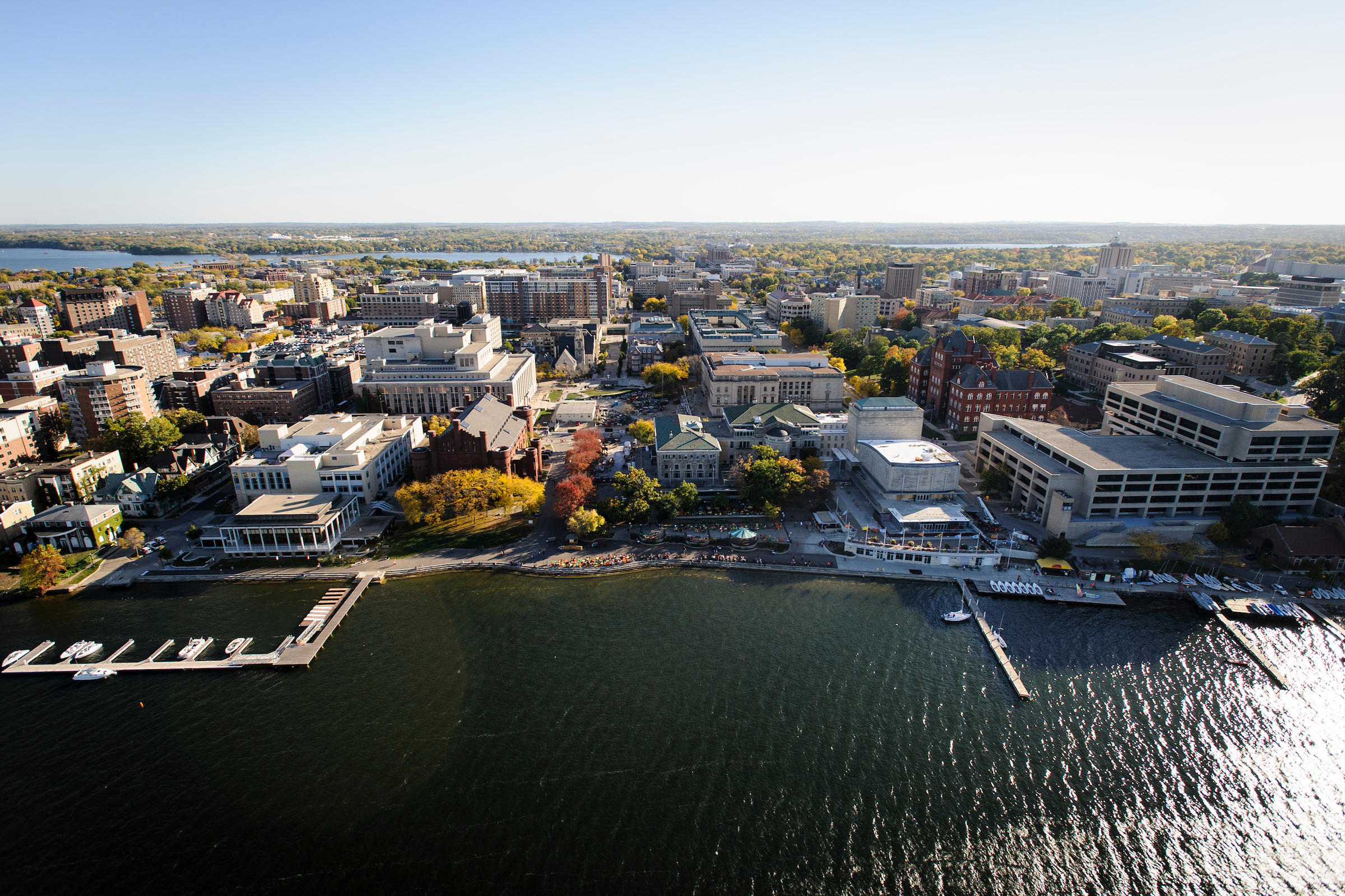 The Lake Mendota shoreline is pictured in an aerial view of the University of Wisconsin-Madison campus during autumn on Oct. 12, 2013. From left to right, major campus facilities include the Goodspeed Family Pier, Below Alumni Center, Pyle Center, Memorial Library, Red Gym (Armory and Gymnasium), construction of the East Campus Mall, Memorial Union Terrace, Wisconsin Union Theater, Science Hall and Helen C. White Hall. The photograph was made from a helicopter looking south. (Photo by Jeff Miller/UW-Madison)