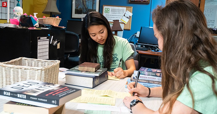 Badger Volunteers Shuka Konishi (left) and Mikayla Sandin (right) responding to a letter from an incarcerated LGBTQ+ people at LGBT Books to Prisoners, a trans-affirming, racial justice-focused, prison abolitionist project that sends books to incarcerated LGBTQ-identified people across the United States.