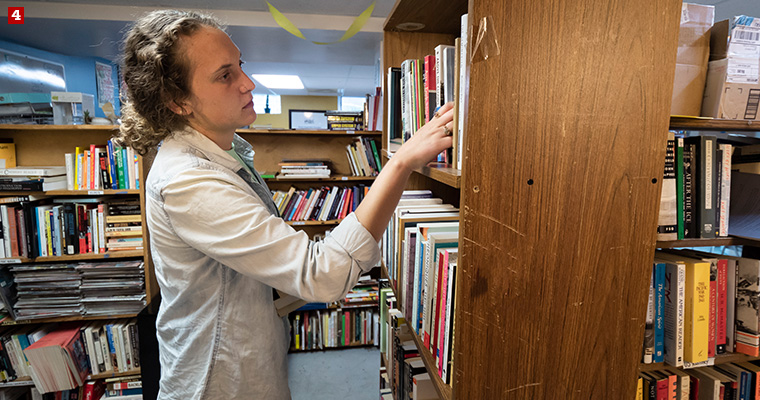 Badger Volunteer Leah Piehl searches for a book requested by incarcerated LGBTQ+ people at LGBT Books to Prisoners, a trans-affirming, racial justice-focused, prison abolitionist project that sends books to incarcerated LGBTQ-identified people across the United States.