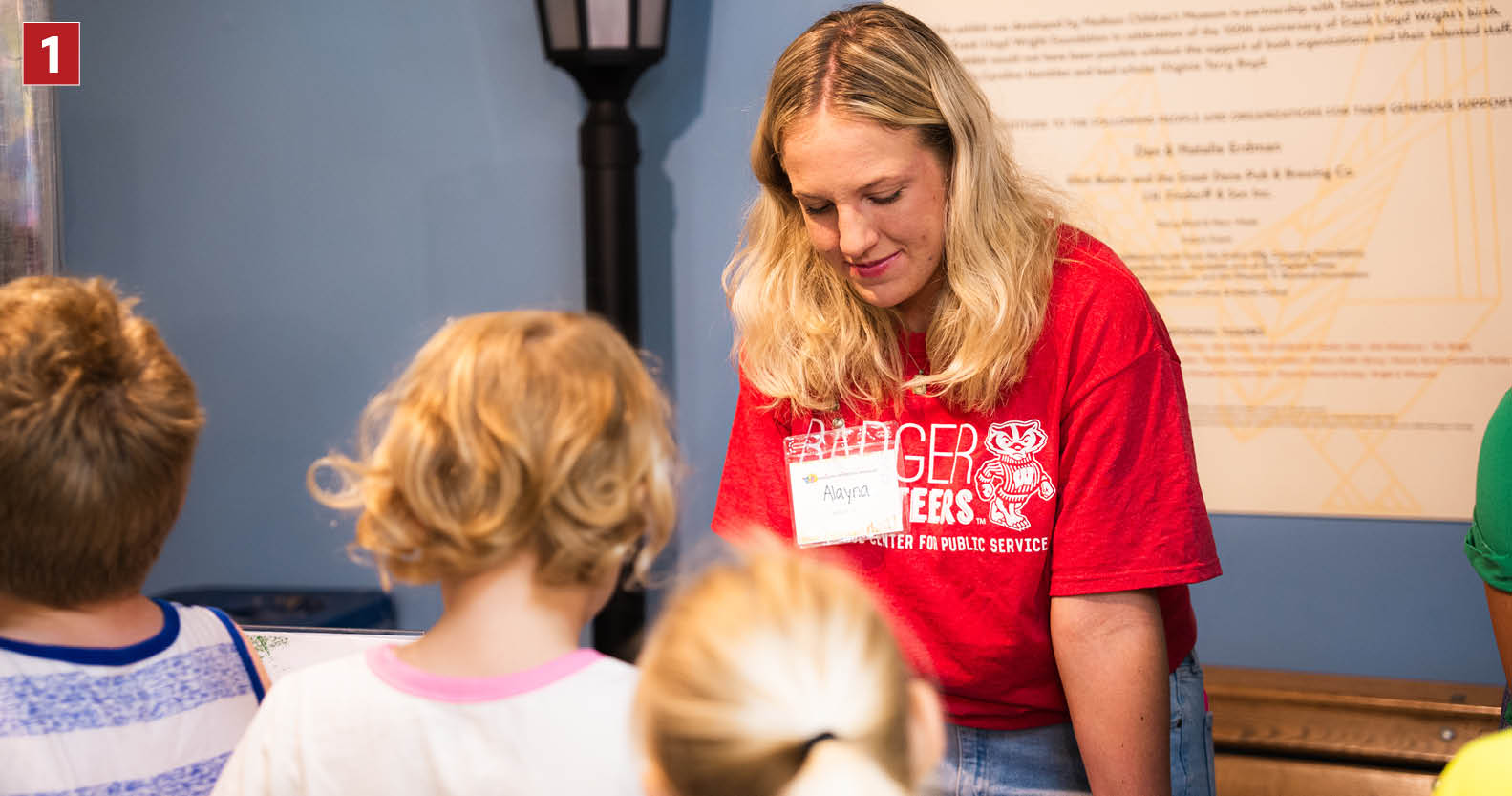 Alayna Westenberg assisting kids at a table at the Madison's Children Museum