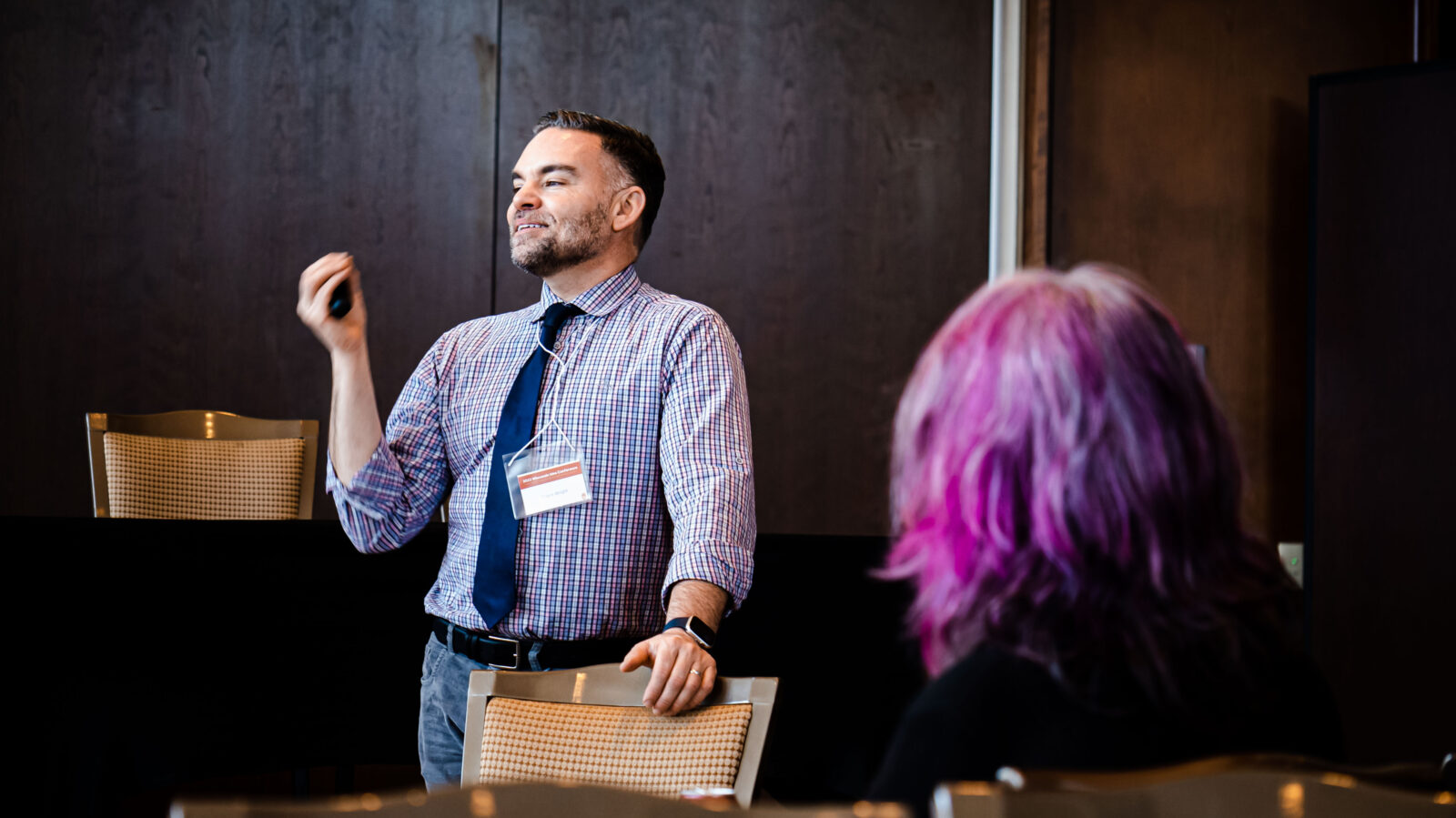Dr. Travis Wright talks to a group of attendees at the 2023 Wisconsin Idea Conference about BASES (Building Academic, Social, and Emotional Support), a project that increases school-based and other educational supports for young children experiencing homelessness in Madison and building the capacity of schools, teachers and families to better meet their needs.